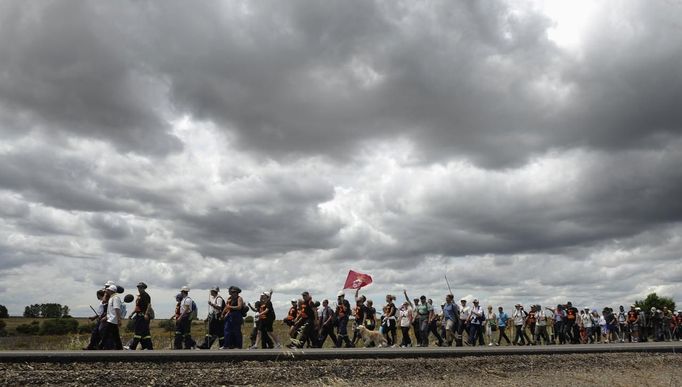 Coal miners and their families march on a national main road N 630 between Robla village and Leon, northern Spain, June 14, 2012. The miners are protesting against the government's proposal to decrease funding for coal production. REUTERS/Eloy Alonso (SPAIN - Tags: CIVIL UNREST BUSINESS EMPLOYMENT ENERGY) Published: Čer. 14, 2012, 4:27 odp.