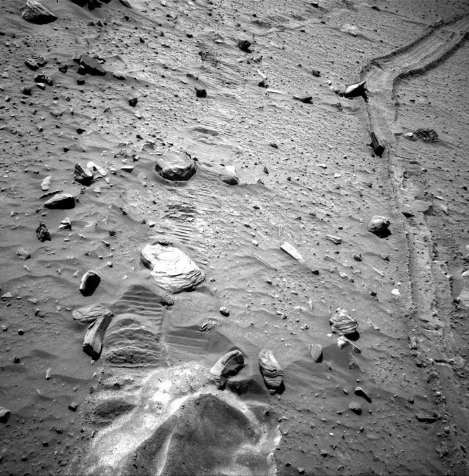 This view from the navigation camera near the top of the mast on NASA's Mars Exploration Rover Spirit shows the tracks left by the rover as it drove southward and backward, dragging its inoperable right-front wheel, to the location where the rover broke through a crust in April 2009 and became embedded in soft sand. The rover team's chosen strategy for beginning the attempt to extricate Spirit from the sand trap is to follow these tracks out, heading north. Spirit took this image during the 2,092nd Martian day, or sol, of the rover's mission on Mars (Nov. 21, 2009). Spirit performed the third planned drive of the extrication attempt on that sol. For scale, the distance between the right and left wheel tracks is about 1 meter (3 feet). The rover team began commanding extrication drives in November after months of Earthbound testing and analysis to develop a strategy for attempting to drive Spirit out of this soft-soil site, called "Troy." The extrication drives are expected to make slow, if any, progress in coming weeks, and the probability of success in escaping from Troy is uncertain. Image Credit: NASA/JPL-Caltech