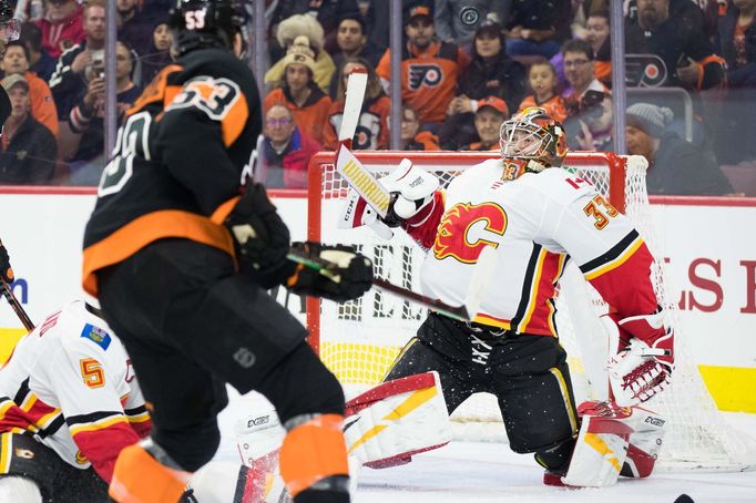 hokej, NHL 2018/2019, Philadelphia - Calgary, David Rittich zasahuje proti pokusu Shayna Gostisbehera