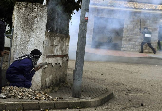 A coal miner aims a rocket at a Guardia Civil officer during clashes in Cinera village near Leon, northern Spain June 19, 2012. The miners were protesting against the government's proposal to decrease funding for coal production. REUTERS/Eloy Alonso (SPAIN - Tags: BUSINESS EMPLOYMENT CIVIL UNREST POLITICS) Published: Čer. 19, 2012, 3:18 odp.