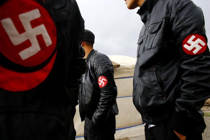 Members of the Mongolian neo-Nazi group Tsagaan Khass stand near a quarry, where they questioned a worker, southwest of Ulan Bator June 23, 2013. The group has rebranded itself as an environmentalist organisation fighting pollution by foreign-owned mines, seeking legitimacy as it sends Swastika-wearing members to check mining permits. Over the past years, ultra-nationalist groups have expanded in the country and among those garnering attention is Tsagaan Khass, which has recently shifted its focus from activities such as attacks on women it accuses of consorting with foreign men to environmental issues, with the stated goal of protecting Mongolia from foreign mining interests. This ultra-nationalist group was founded in the 1990s and currently has 100-plus members. Picture taken June 23, 2013. REUTERS/Carlos Barria (MONGOLIA - Tags: POLITICS ENVIRONMENT BUSINESS SOCIETY EMPLOYMENT) ATTENTION EDITORS: PICTURE 19 OF 25 FOR PACKAGE 'MONGOLIA'S ENVIRONMENTAL NEO-NAZIS'. TO FIND ALL IMAGES SEARCH 'TSAGAAN KHASS' Published: Čec. 2, 2013, 9:58 dop.