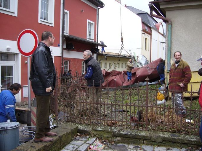 Začínají odklízecí práce na popadané plechové střeše.