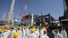 Members of the media wearing protective suits and masks are escorted by TEPCO employees as they go on a visit near the No.4 reactor (C) and its foundation construction (R) for the storage of melted fuel rods at Tokyo Electric Power Company's (TEPCO) tsunami-crippled Fukushima Daiichi nuclear power plant in Fukushima prefecture March 6, 2013, ahead of the second-year of anniversary of the disaster. Members of the media were allowed into the plant on Wednesday ahead of the second-year anniversary of the March 11, 2011 tsunami and earthquake, which triggered the world's worst nuclear crisis since Chernobyl. REUTERS/Issei Kato (JAPAN - Tags: DISASTER ANNIVERSARY) Published: Bře. 6, 2013, 11:24 dop.