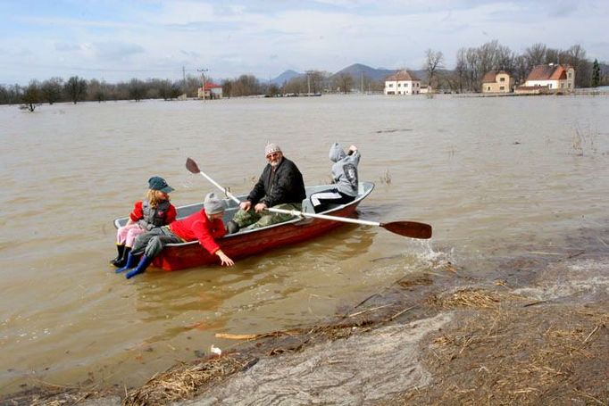 Pan Boček Kabeláč vozí po jezeře děti.