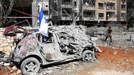 Ramat Gan: záchranář prochází kolem zničeného auta na místě dopadu rakety v Ramat Ganu.