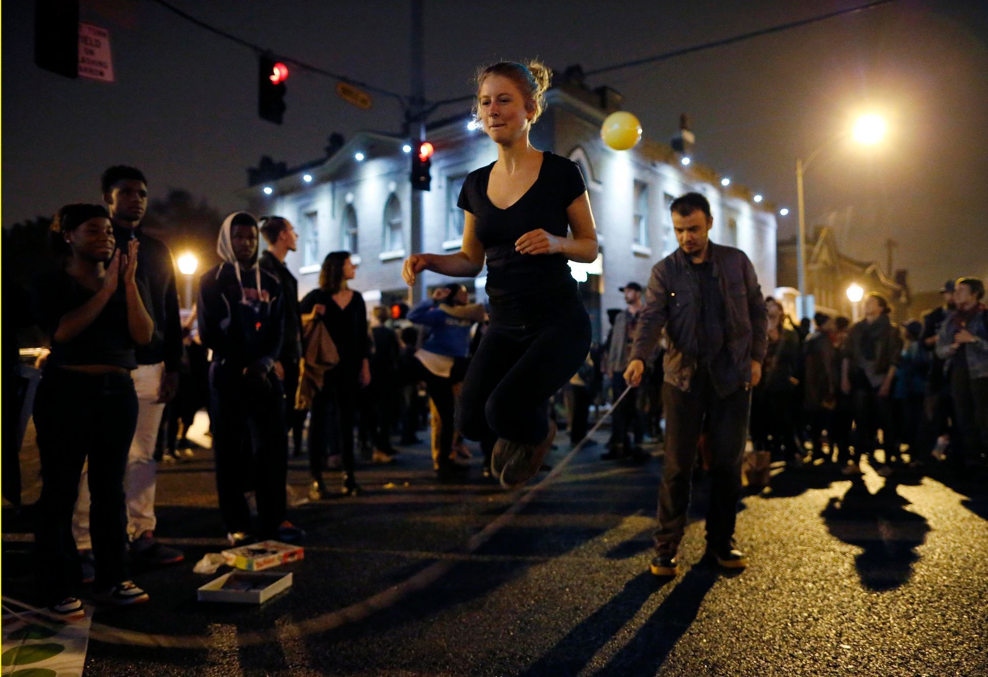 Prostestující skakající přes švihadlo při blokádě křižovatky během pochodu v St. Louis
