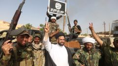 Šíitští bojovníci, podporující iráckou armádu, s ukořistěným billboardem Islámského státu ve Fallúdži.