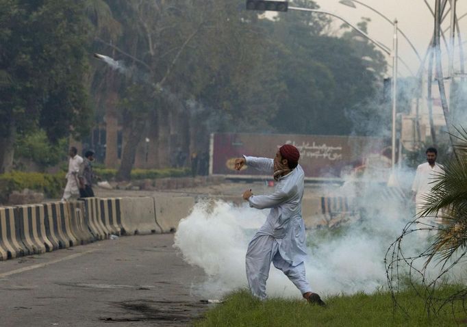 A supporter throws a teargas canister, which was earlier thrown by police, during clashes along a road which leads to the U.S. embassy in Islamabad September 20, 2012. Some 800 protesters march towards the U.S. embassy gathered in a demonstration to condemn a film produced in the U.S. mocking the Prophet Mohammad. REUTERS/Faisal Mahmood (PAKISTAN - Tags: POLITICS CIVIL UNREST RELIGION) Published: Zář. 20, 2012, 2:57 odp.