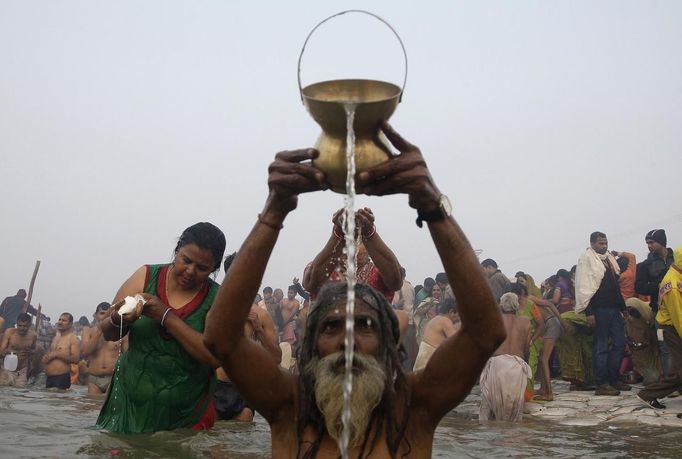 Hindu devotees pray as they attend the first "Shahi Snan" (grand bath) at the ongoing "Kumbh Mela", or Pitcher Festival, in the northern Indian city of Allahabad January 14, 2013. Upwards of a million elated Hindu holy men and pilgrims took a bracing plunge in India's sacred Ganges river to wash away lifetimes of sins on Monday, in a raucous start to an ever-growing religious gathering that is already the world's largest. REUTERS/Jitendra Prakash (INDIA - Tags: RELIGION SOCIETY) Published: Led. 14, 2013, 8:29 dop.