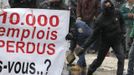 An Arcelor Mittal worker from Liege throws a stone next to a banner reading "10,000 jobs lost", during a demonstration outside Prime Minister Elio Di Rupo's office where a political meeting is taking place, in Brussels January 25, 2013. ArcelorMittal, the world's largest steel producer, plans to shut a coke plant and six fininishing lines at its site in Liege Belgium, affecting 1,300 employees, the group said on Thursday. REUTERS/Yves Herman (BELGIUM - Tags: BUSINESS CIVIL UNREST BUSINESS EMPLOYMENT) Published: Led. 25, 2013, 12:22 odp.