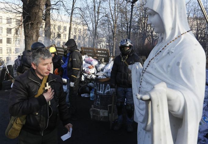 Anti-government protesters pray at a religious statue in Kiev February 21, 2014.