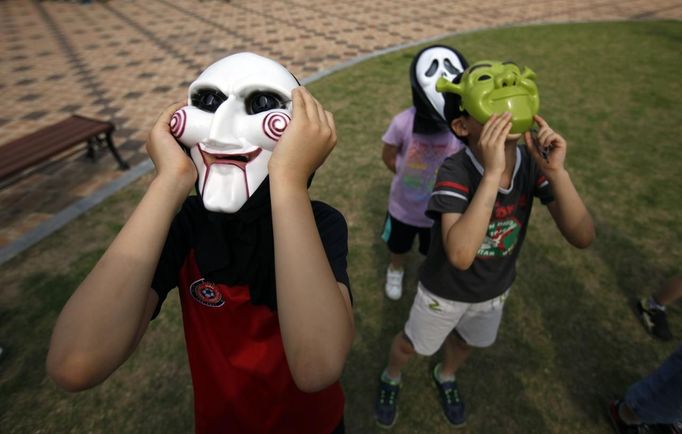 South Korean primary school students wearing masks with solar viewers watch Venus passing between the Sun and the Earth at the Gwacheon National Science Museum in Gwacheon, south of Seoul, June 6, 2012. One of the rarest astronomical events occurs on Wednesday when Venus passes directly between the sun and Earth, a transit that won't occur again until 2117. REUTERS/Kim Hong-Ji (SOUTH KOREA - Tags: ENVIRONMENT) Published: Čer. 6, 2012, 1:08 dop.