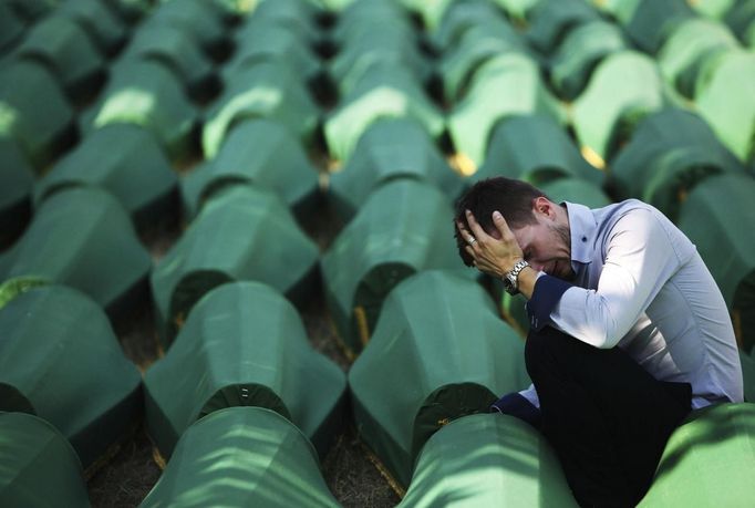 A Bosnian Muslim man sits and cries near the coffin of his relative at Memorial Center in Potocari before a mass burial, near Srebrenica July 11, 2012. The bodies of 520 recently identified victims of the Srebrenica massacre will be buried on July 11, the anniversary of the massacre when Bosnian Serb forces commanded by Ratko Mladic slaughtered 8,000 Muslim men and boys and buried them in mass graves, in Europe's worst massacre since World War Two. REUTERS/Dado Ruvic (BOSNIA - Tags: CONFLICT OBITUARY SOCIETY ANNIVERSARY)