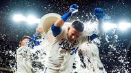 Kansas City, USA: Euforie v modrém, baseballista Freddy Fermin se nechává polít vítěznou sprchou, zatímco spoluhráči slaví triumf domácího týmu Kansas City
Royals a stadion burácí radostí.