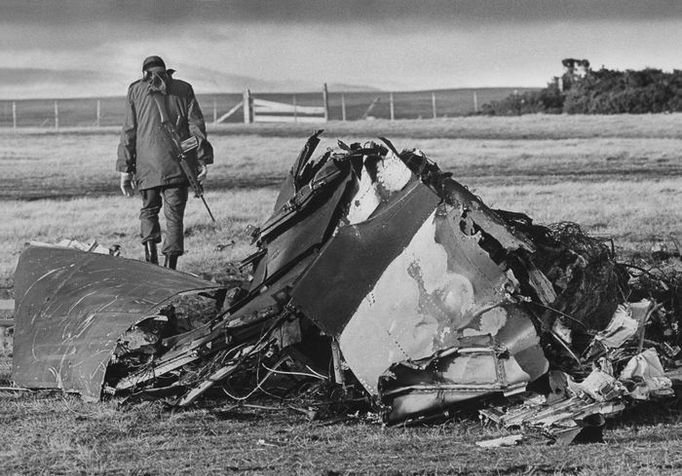 Argentinský voják prochází kolem sestřeleného britského bojového letounu v Darwinu. (Archivní snímek z května 1982)