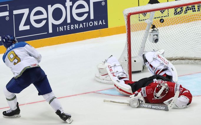 Kazakhstan's Nigel Dawes scores on Switzerland's Reto Berra