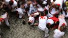 Runners fall down and form a "Montonera" (Many People) at the entrance to the bullring during the first running of the bulls of the San Fermin festival in Pamplona July 7, 2012. One person was gored and four others injured in a run by Dolores Aguirre fighting bulls that lasted two minutes and fifty-two seconds, according to local media. REUTERS/Vincent West (SPAIN - Tags: ANIMALS SOCIETY) Published: Čec. 7, 2012, 9:13 dop.