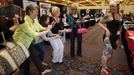 A group of women from an adjacent quilting fair sneak into the National Tattoo Association Convention in Cincinnati to take a picture of a heavily-tattooed convention-goer in Ohio April 14, 2012. The hobby of collecting tattoos has exploded into the mainstream of society with tattoo conventions and festivals held year-round across the United States. Picture taken April 14, 2012. REUTERS/Larry Downing (UNITED STATES - Tags: SOCIETY) ATTENTION EDITORS PICTURE 16 OF 31 FOR PACKAGE 'ADDICTED TO THE NEEDLE' TO FIND ALL PICTURES SEARCH 'ADDICTED NEEDLE' Published: Čer. 29, 2012, 12:59 odp.