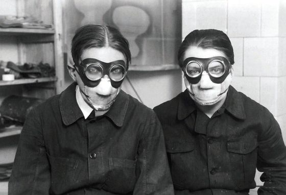 Malíři Štyrský a Toyen v maskách při práci s "Deka" barvami.
