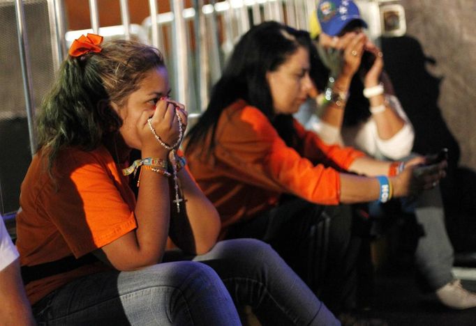 Supporters of Venezuela's opposition presidential candidate Henrique Capriles await results of the presidential election against President Hugo Chavez, outside the Capriles' press center in Caracas October 7, 2012. Venezuela's socialist President Chavez won re-election in Sunday's vote with 54 percent of the ballot to beat opposition challenger Henrique Capriles. REUTERS/Carlos Garcia Rawlins (VENEZUELA - Tags: POLITICS ELECTIONS) Published: Říj. 8, 2012, 2:44 dop.