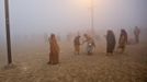 Hindu devotees walk on the banks of the river Ganges amidst the fog ahead of the "Kumbh Mela" (Pitcher Festival) in the northern Indian city of Allahabad January 13, 2013. During the festival, Hindus take part in a religious gathering on the banks of the river Ganges. "Kumbh Mela" will return to Allahabad in 12 years. REUTERS/Ahmad Masood (INDIA - Tags: RELIGION SOCIETY) Published: Led. 13, 2013, 6:49 dop.