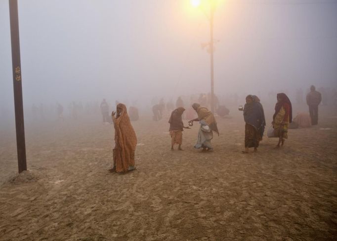 Hindu devotees walk on the banks of the river Ganges amidst the fog ahead of the "Kumbh Mela" (Pitcher Festival) in the northern Indian city of Allahabad January 13, 2013. During the festival, Hindus take part in a religious gathering on the banks of the river Ganges. "Kumbh Mela" will return to Allahabad in 12 years. REUTERS/Ahmad Masood (INDIA - Tags: RELIGION SOCIETY) Published: Led. 13, 2013, 6:49 dop.