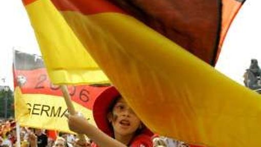 Německá fanynka mává vlajkou v ulicích Stuttgartu před zápasem o bronz s Portugalskem.