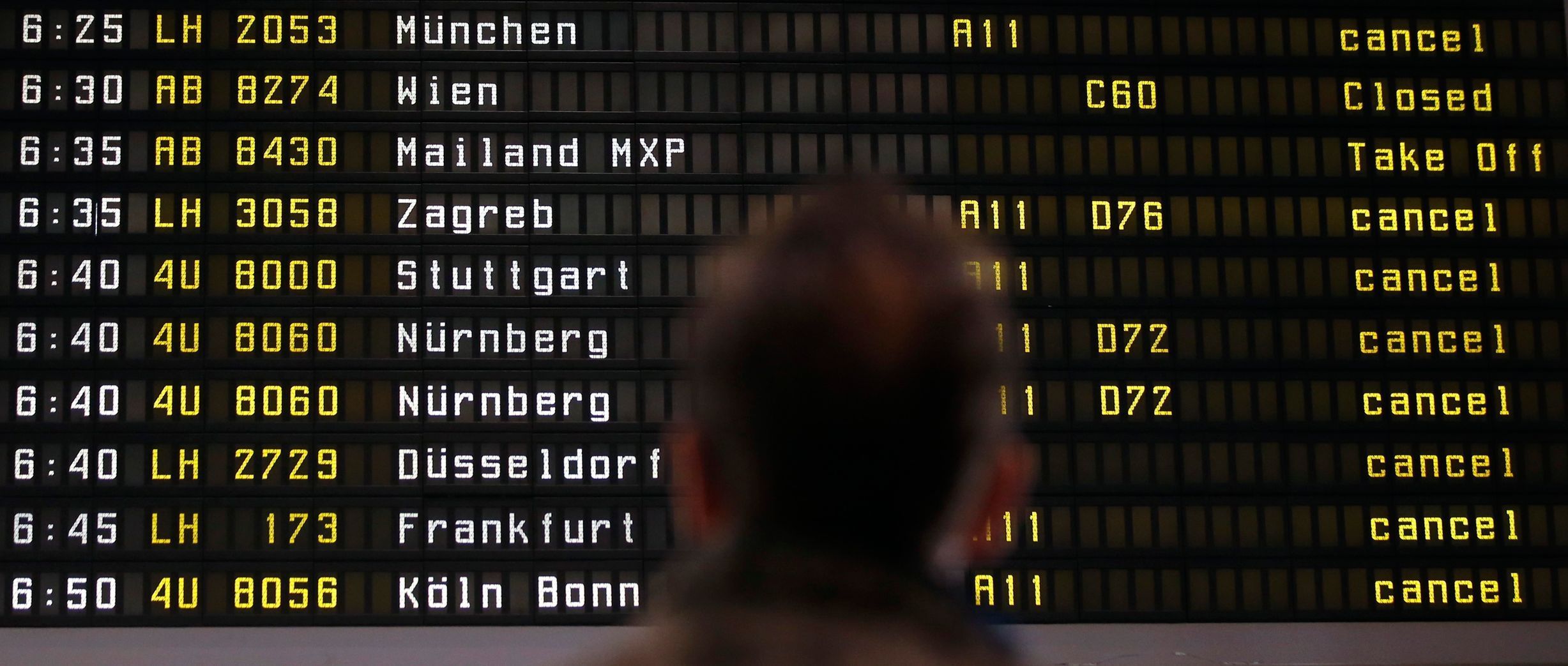A man looks at cancelled flights by German air carrier Lufthansa on a flight schedule board in Berlin Tegel airport