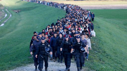 Uprchlíci za doprovodu policie procházejí Slovinskem.