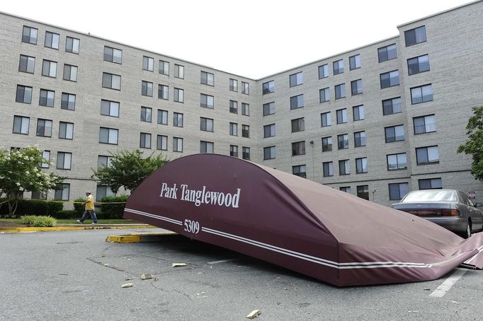 The dislodged awning of the storm-damaged Park Tanglewood apartments, some of which were exposed when high winds tore open a hole in the roof and knocked out the electricity, sits in the parking lot in Riverdale, Maryland, June 30, 2012. Wind gusts clocked at speeds of up to 79 mph were reported in and around the U.S. capital, knocking out power to hundreds of thousands of homes in the Washington, D.C., area. REUTERS/Jonathan Ernst (UNITED STATES - Tags: ENVIRONMENT DISASTER) Published: Čer. 30, 2012, 9:20 odp.