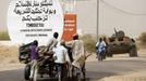 People drive past a road sign written by Islamist rebels at the entrance into Timbuktu January 31, 2013. Mali's president offered Tuareg rebels talks on Thursday in a bid for national reconciliation after a French-led offensive drove their Islamist former allies into mountain hideaways. The sign reads, "The gate of the application of sharia law welcomes you." REUTERS/Benoit Tessier (MALI - Tags: POLITICS CIVIL UNREST CONFLICT MILITARY) Published: Led. 31, 2013, 7:35 odp.