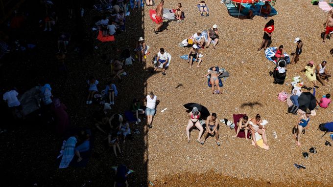 Záběry ze zaplněné pláže v Brightonu. Vysoké teploty vyhnaly Brity k vodě.