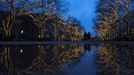 Trees decorated with Christmas lights are reflected in a puddle as people walk along the Unter den Linden promenade in Berlin November 28, 2012. REUTERS/Thomas Peter (GERMANY - Tags: SOCIETY ENVIRONMENT TPX IMAGES OF THE DAY) Published: Lis. 28, 2012, 3:48 odp.