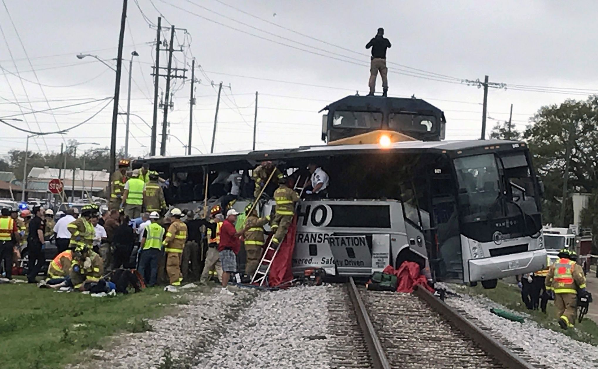 Hasiči pomáhají cestujícím po srážce vlaku s autobusem v americkém Biloxi.