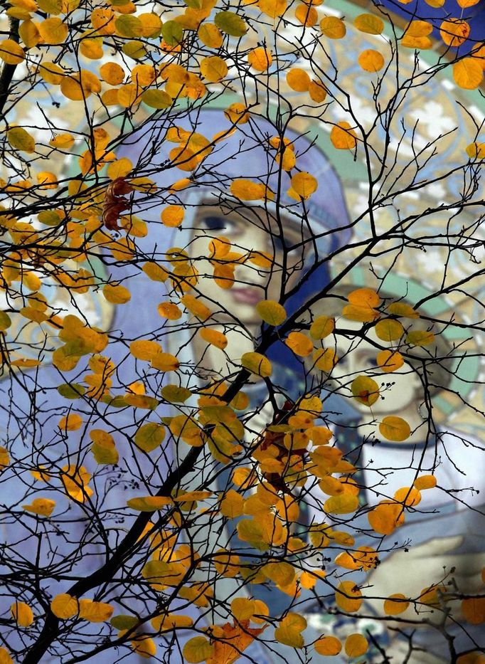 A fresco is seen through autumn leaves in a park in St. Petersburg October 14, 2012. REUTERS/Alexander Demianchuk (RUSSIA - Tags: RELIGION ENVIRONMENT TPX IMAGES OF THE DAY) Published: Říj. 14, 2012, 1:21 odp.