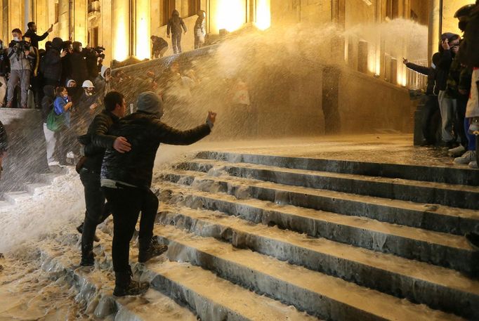 Strážci zákona zadržují muže během shromáždění proti zákonu o "zahraničních agentech" v gruzínském Tbilisi.