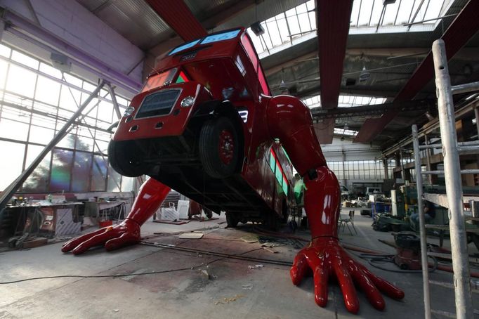 A London bus that has been transformed into a robotic sculpture by Czech artist David Cerny performs press-ups at a factory hall in Prague July 2, 2012. The bus, which Cerny hopes could become an unofficial mascot of the games, does push-ups with the help of an engine powering a pair of robotic arms, and the motion is accompanied by a recording of sounds evoking tough physical effort. It will be parked outside the Czech Olympic headquarters in London for the duration of the Games. Picture taken July 2, 2012. REUTERS/Petr Josek (CZECH REPUBLIC - Tags: SOCIETY SPORT OLYMPICS TRANSPORT) Published: Čec. 22, 2012, 5:59 odp.