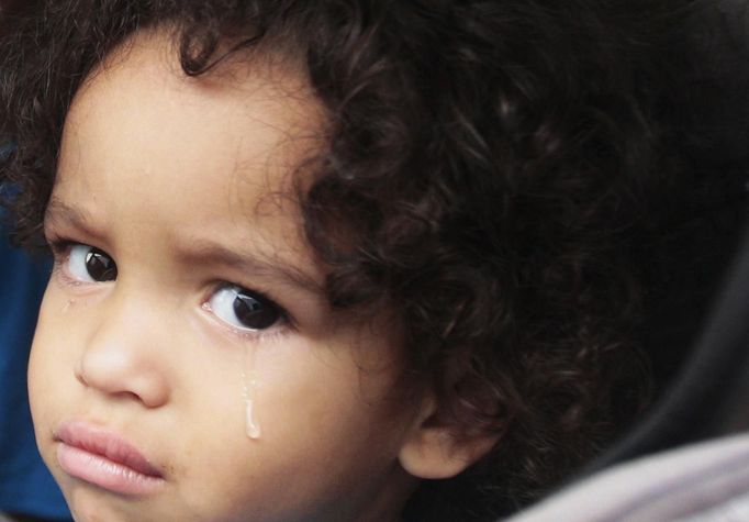 Jaden Fabian, 1, cries in her car seat as her family evacuates their home as Tropical Storm Isaac heads towards the Louisiana coast line in Oakville, Louisiana, August 28, 2012. Tropical Storm Isaac was near hurricane force as it bore down on the U.S. Gulf Coast on Tuesday and was expected to make landfall in the New Orleans area seven years after it was devastated by Hurricane Katrina. REUTERS/Sean Gardner (UNITED STATES - Tags: ENVIRONMENT TPX IMAGES OF THE DAY DISASTER) Published: Srp. 28, 2012, 2:07 odp.