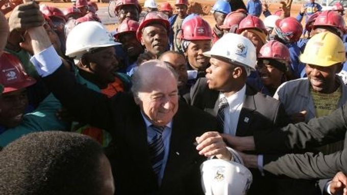 Sepp Blatter se zdraví s dělníky během jeho návštěvy v JAR, kde se bude v roce 2010 konat MS ve fotbale.