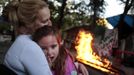 Gema Pardo consoles her daughter Amanda as they sit next to a bonfire with relatives at the Spanish gypsy settlement of Puerta de Hierro outside Madrid October 20, 2011. Fifty-four families have been living in Puerta de Hierro, on the banks of the Manzanares river for over 50 years. Since the summer of 2010, the community has been subject to evictions on the grounds that the dwellings are illegal. Families whose houses have been demolished, move in with relatives whose houses still remain while the debris keeps piling up around them as more demolitions take place. Picture taken October 20, 2011. REUTERS/Susana Vera (SPAIN - Tags: SOCIETY) ATTENTION EDITORS - PICTURE 16 OF 31 FOR PACKAGE 'GYPSY SITE DEMOLISHED' SEARCH 'GYPSY SITE' FOR ALL IMAGES Published: Lis. 5, 2012, 4:11 odp.