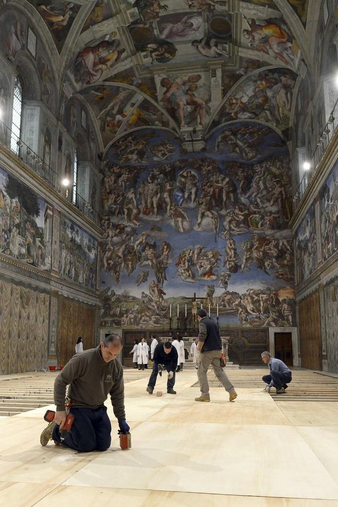 Workers cover the floor of the Sistine Chapel at the Vatican March 8, 2013. Roman Catholic cardinals will start their conclave to elect a successor to Pope Benedict on the afternoon of Tuesday March 12, the Vatican said in a statement on Friday. REUTERS/ Osservatore Romano ( VATICAN - Tags: RELIGION) ATTENTION EDITORS - THIS IMAGE WAS PROVIDED BY A THIRD PARTY. FOR EDITORIAL USE ONLY. NOT FOR SALE FOR MARKETING OR ADVERTISING CAMPAIGNS. THIS PICTURE IS DISTRIBUTED EXACTLY AS RECEIVED BY REUTERS, AS A SERVICE TO CLIENTS Published: Bře. 8, 2013, 5:27 odp.