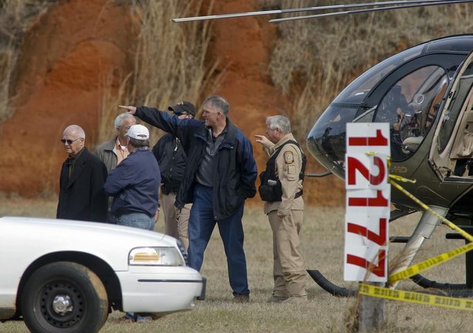 Law enforcement officials talk at a roadblock near the scene of a shooting and hostage taking near Midland City, Alabama February 1, 2013. Residents in a rural Alabama town prayed on Friday and called for the release of a 5-year-old boy being held captive for a fourth day by a man accused of shooting a school bus driver and then taking the child hostage. REUTERS/Phil Sears (UNITED STATES - Tags: CRIME LAW) Published: Úno. 1, 2013, 9:32 odp.