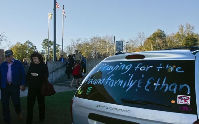 People pass a sign on a vehicle as they leave the funeral for bus driver Charles Albert Poland Jr. at Ozark Civic Center, near Midland City, Alabama, February 3, 2013. Mourners in the small town of Midland City, Alabama, gathered on Sunday to bury a school bus driver slain during the abduction of a child taken captive and held for a sixth day by a gunman in an underground bunker. REUTERS/Phil Sears (UNITED STATES - Tags: CRIME OBITUARY) Published: Úno. 4, 2013, 1:17 dop.