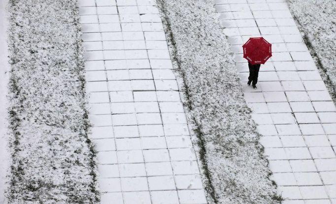 A pedestrian walks under an umbrella during snowfall in Russia's Siberian city of Krasnoyarsk October 20, 2012. REUTERS/Ilya Naymushin (RUSSIA - Tags: SOCIETY TPX IMAGES OF THE DAY ENVIRONMENT) Published: Říj. 20, 2012, 8:52 dop.