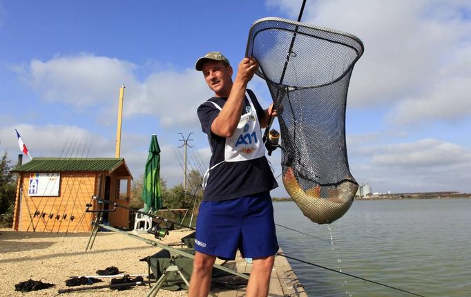 Mickael Regny of France catches a carp during the 14th Carpfishing World Championship in Corbu village, 310 km (192 miles) east of Bucharest, September 29, 2012. REUTERS/Radu Sigheti (ROMANIA - Tags: SOCIETY) Published: Zář. 29, 2012, 4:22 odp.