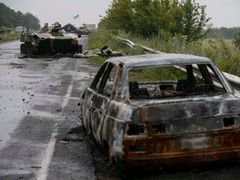 Zbytky aut a tanků na silnici nedaleko východoukrajinského Slavjansku.