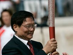 Olympijská pochodeň v rukou prezidenta čínského olympijského výboru Liu Qi.