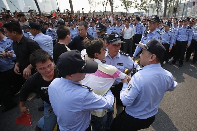 Policemen arrest a protester, as a fellow protester tries to drag him back, at the Bund along the Huangpu River in Shanghai September 18, 2012. Hundreds of Japanese businesses and the country's embassy suspended services in China on Tuesday, as anti-Japan protests threatened to reignite and drag a territorial dispute between Asia's two biggest economies deeper into crisis. REUTERS/Aly Song (CHINA - Tags: POLITICS CIVIL UNREST)