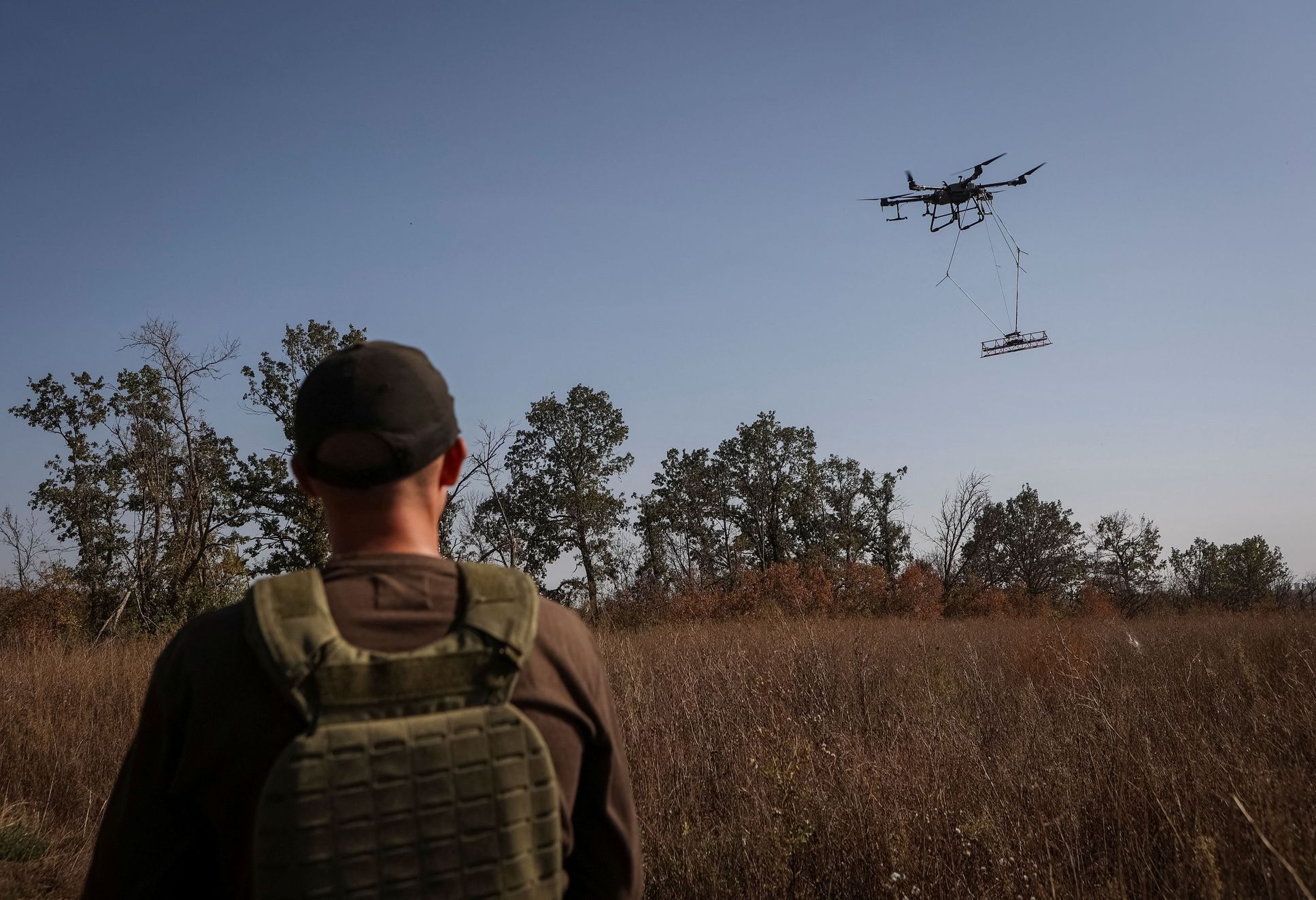 Specialista ovládá odminovávací dron nad polem u města Derhači na severovýchodě Ukrajiny.