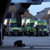 Muž se modlí, zatímco vojáci a záchranáři čekají na ostatky pasažérů havarovaného ruského letadla.